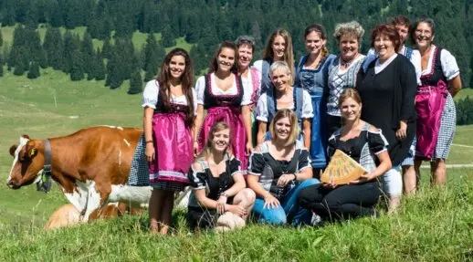 une photo de groupe avec des dames souriantes en tenues traditionnelles